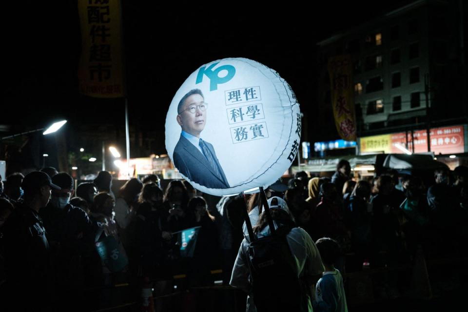 A woman carries a balloon with the portrait of the Taiwan People’s Party (TPP) presidential candidate Ko Wen-je (AFP/Getty)