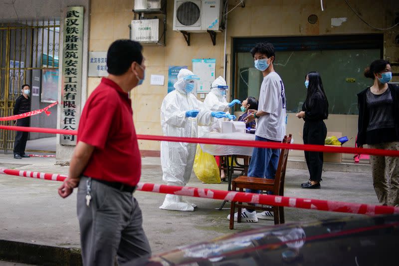 FILE PHOTO: Medical workers in protective suits conduct nucleic acid testings for residents at a residential compound in Wuhan