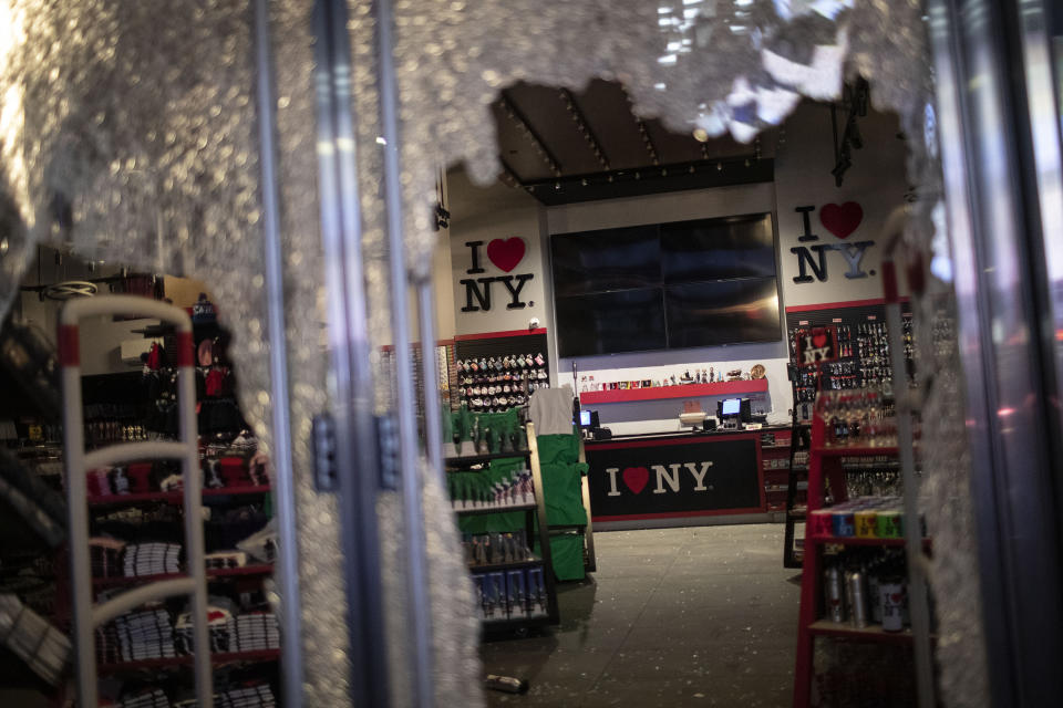 The glass door of a souvenir shop is shattered as people broke into it hours after a solidarity rally calling for justice over the death of George Floyd Monday, June 1, 2020, in New York. Floyd died after being restrained by Minneapolis police officers on May 25. (AP Photo/Wong Maye-E)