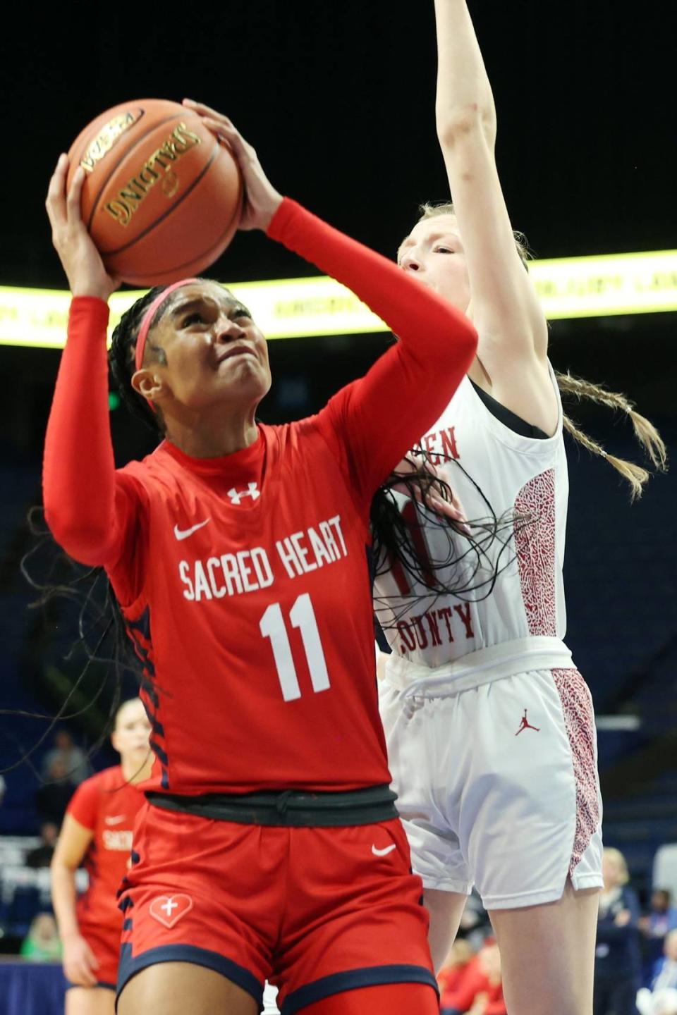 ZaKiyah Johnson (11) helped lead Sacred Heart Academy to its fourth consecutive Kentucky high school basketball state championship in Rupp Arena last month. James Crisp
