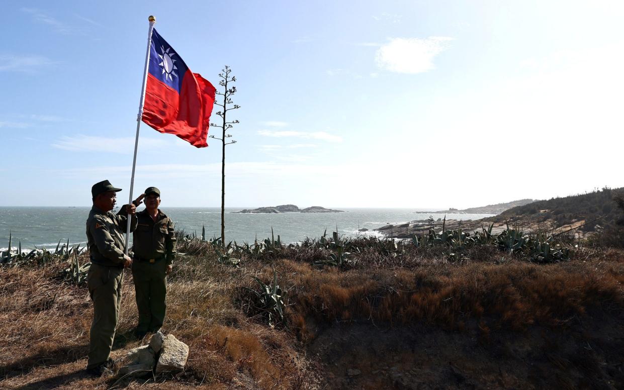 Veterans take part in a flag raising ceremony at a former military post on Kinmen, Taiwan, the last place where there was major major fighting with China in 1958 - ANN WANG /REUTERS 