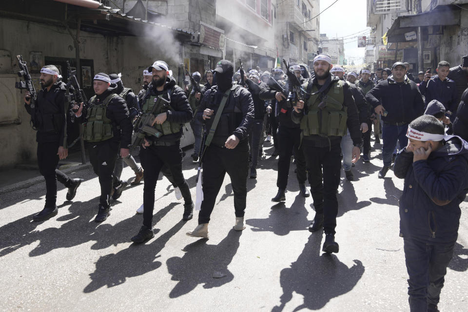 Palestinians gunmen shoot in the air during the funeral of Nader Rayan, 16, who was killed by Israeli forces during a raid at Balata refugee camp near the West Bank city of Nablus, Tuesday, March 15, 2022. (AP Photo/Majdi Mohammed)