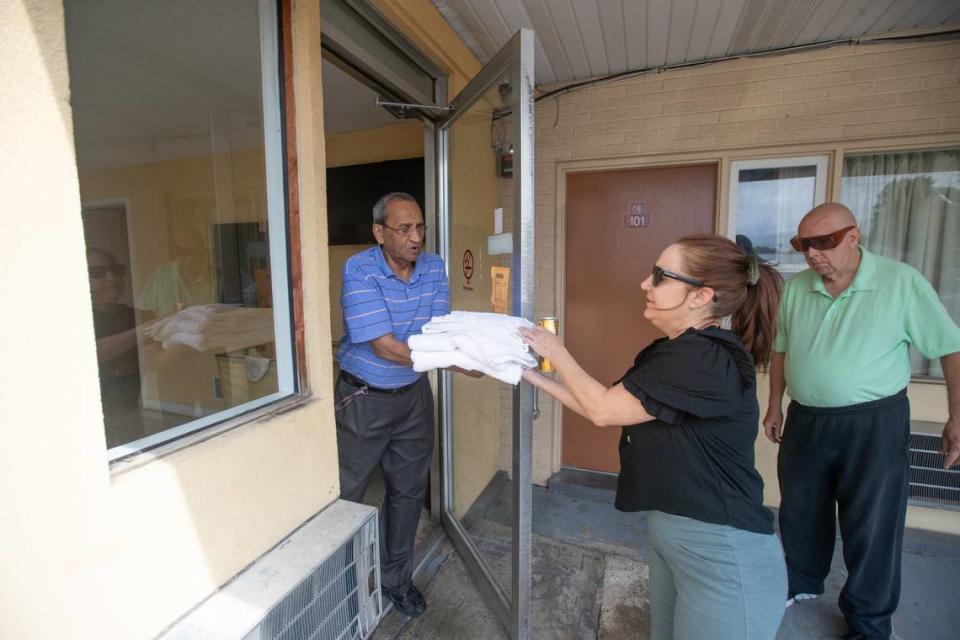 A manager of the Town House Motel in Belleville hands towels to Diane Burrelsman, a friend of guest David Semrau, right, who was evicted from his home. He’s very particular about cleanliness. Joshua Carter/jcarter@bnd.com