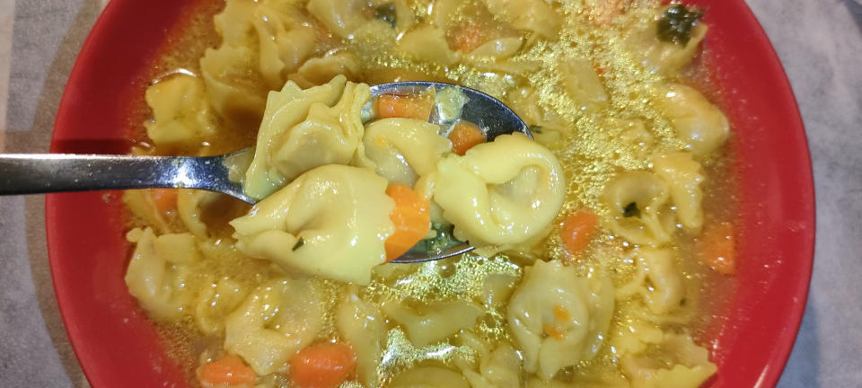 Bowl of chicken noodle soup with vegetables and a spoon