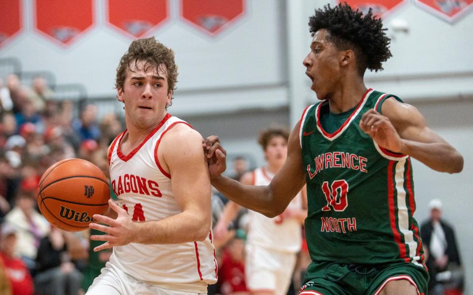 New Palestine High School's Blaine Nunnally (14) works a possession as he is guarded by Lawrence North High School's Ty Cunningham (10) at NPHS, Monday, Jan. 30, 2023, during a game won by LNHS. 
