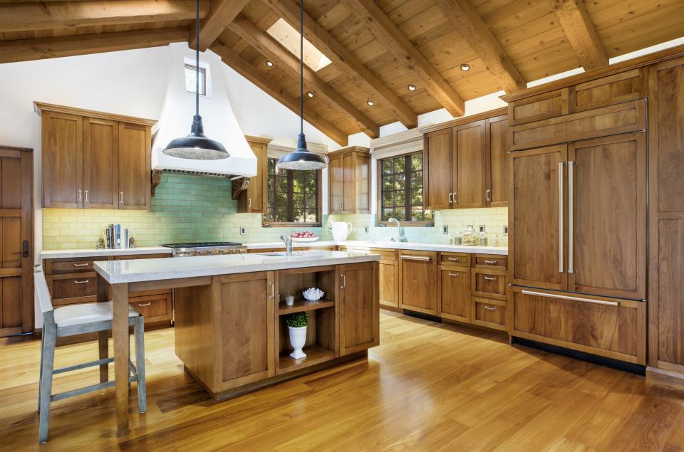 The kitchen features plenty of wood and a colorful backsplash.