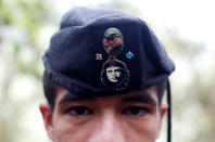 <p>Eduar, a member of the 51st Front of the Revolutionary Armed Forces of Colombia (FARC), is seen wearing a cap with badges showing images of Che Guevara and FARC’s late founder Manuel Marulanda at a camp in Cordillera Oriental, Colombia, August 16, 2016. (John Vizcaino/Reuters) </p>