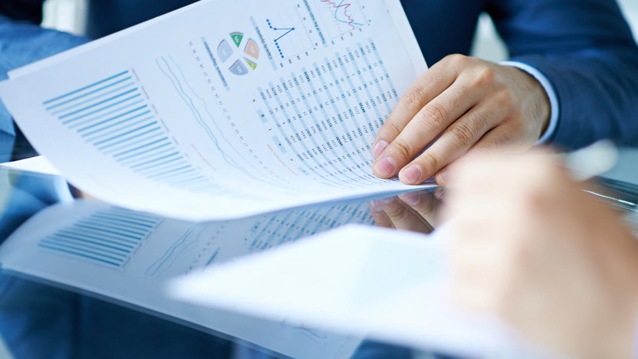 Hands of businessman examining financial report.