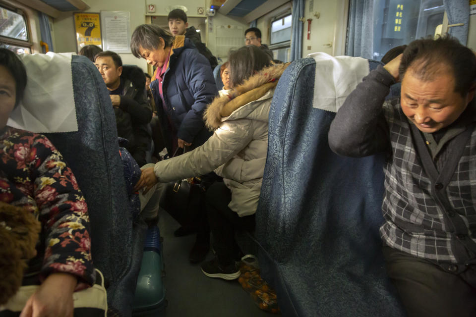 Passengers wait to depart on board their train at the Beijing Railway Station in Beijing, Friday, Jan. 17, 2020. As the Lunar New Year approached, Chinese travelers flocked to train stations and airports Friday to take part in a nationwide ritual: the world's biggest annual human migration. (AP Photo/Mark Schiefelbein)