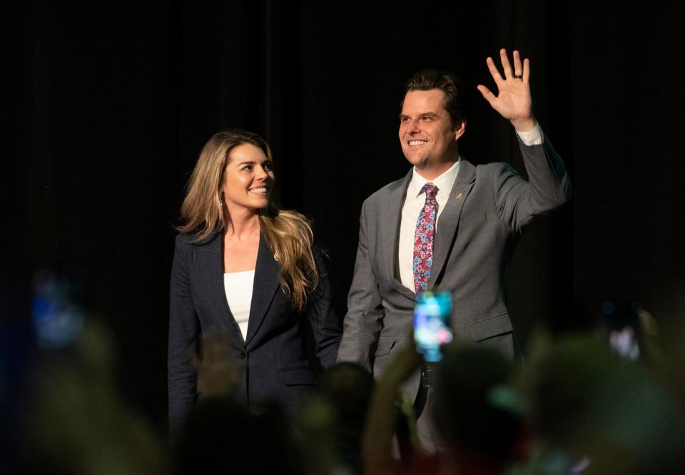 U.S. Rep Matt Gaetz and wife Ginger Luckey wave at a rally for former President Donald Trump at the Palm Beach County Convention Center in West Palm Beach on Oct.11, 2023.