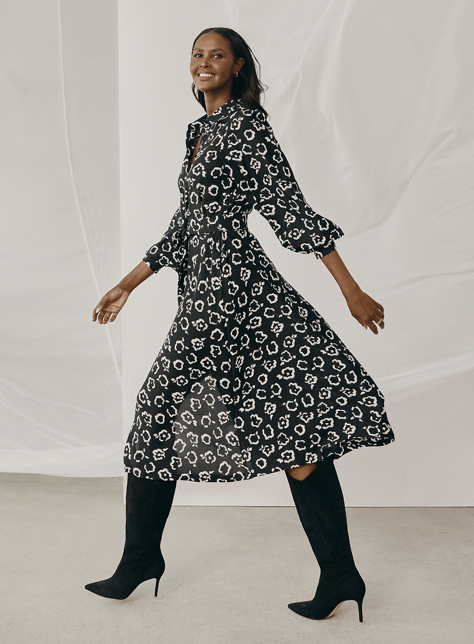 woman wearing knee high black heel boots and black and white Contrasting Garden Shirtdress (photo via Simons)