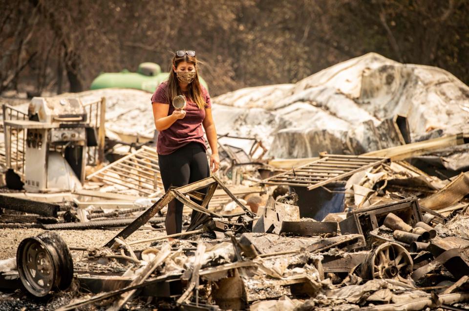 A woman stands in the rubble of her home (AFP via Getty Images)