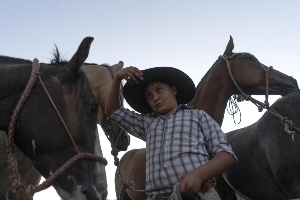 A young gauchos grabs the rim of his hat as the Uruguayan horsemen gather at the Rural Association building ahead of their official participation in the inaugural festivities for President-elect Luis Lacalle Pou, in Montevideo, Uruguay, Saturday, Feb. 29, 2020. Lacalle Pou, a 46-year-old lawyer and a former senator, will be sworn-in as the country's new president on Sunday. (AP Photo/Matilde Campodonico)