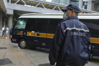 A prison van arrives as a police officer stands guard for Tong Ying-kit's arrival at the Hong Kong High Court in Hong Kong Friday, July 30, 2021. Tong was convicted Tuesday of inciting secession and terrorism for driving his motorcycle into a group of police officers during a July 1, 2020, pro-democracy rally while carrying a flag bearing the banned slogan, "Liberate Hong Kong, revolution of our times." Tong, 24, will be sentenced Friday, the court announced. (AP Photo/Vincent Yu)