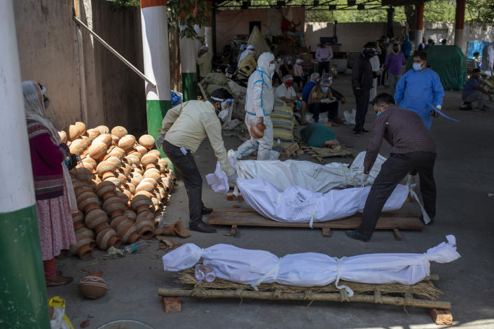 People line up dead bodies of those who died of COVID-19 at a crematorium, in New Delhi, India, Saturday, April 24, 2021. Delhi has been cremating so many bodies of coronavirus victims that authorities are getting requests to start cutting down trees in city parks, as a second record surge has brought India's tattered healthcare system to its knees. (AP Photo/Altaf Qadri)