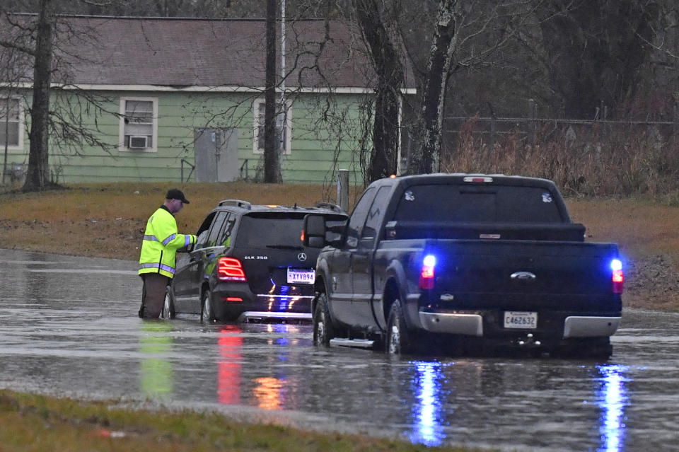 An East Baton Rouge Parish Sheriff's deputy speaks with a stranded motorist on Groom Road near Leland Avenue before pulling the woman to safety, Thursday, Dec. 27, 2018, as severe weather impacts the area in Baker, La. (Hilary Scheinuk/The Advocate via AP)