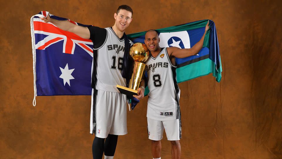 Mills holds up his Torres Strait Islander flag after winning the 2014 title. Pic: Getty