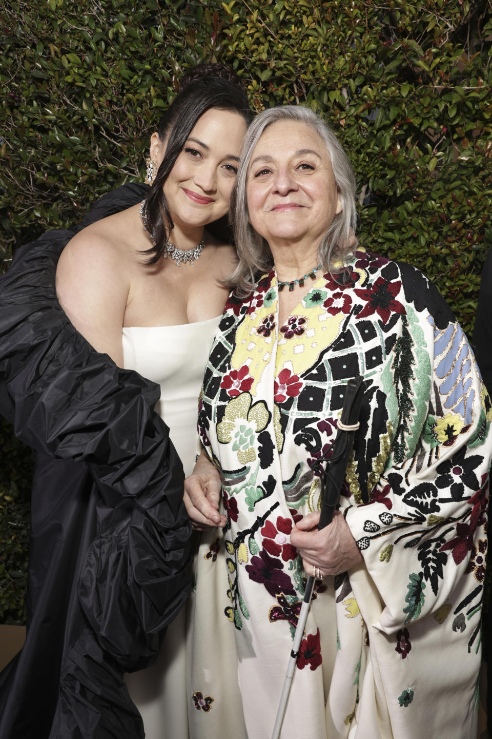 Lily leaning close to her mother for a picture on the red carpet