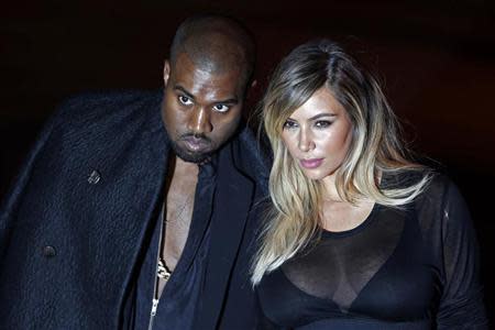 U.S. musician Kanye West (L) and companion Kim Kardashian arrive at the Givenchy Spring/Summer 2014 women's ready-to-wear fashion show during Paris Fashion Week September 29, 2013. REUTERS/Charles Platiau