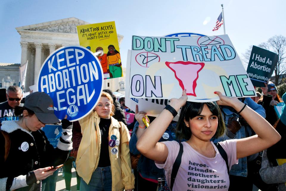 In this Wednesday, March 4, 2020 file photo, abortion rights demonstrators including Jaylene Solache, of Dallas, Texas, right, rally outside the Supreme Court in Washington. In some states, the 2020 COVID-19 coronavirus outbreak has fueled attempts to ban abortions. Where the procedure remains available, some abortion providers report increased demand, often from women distraught over economic stress and health concerns linked to the pandemic.