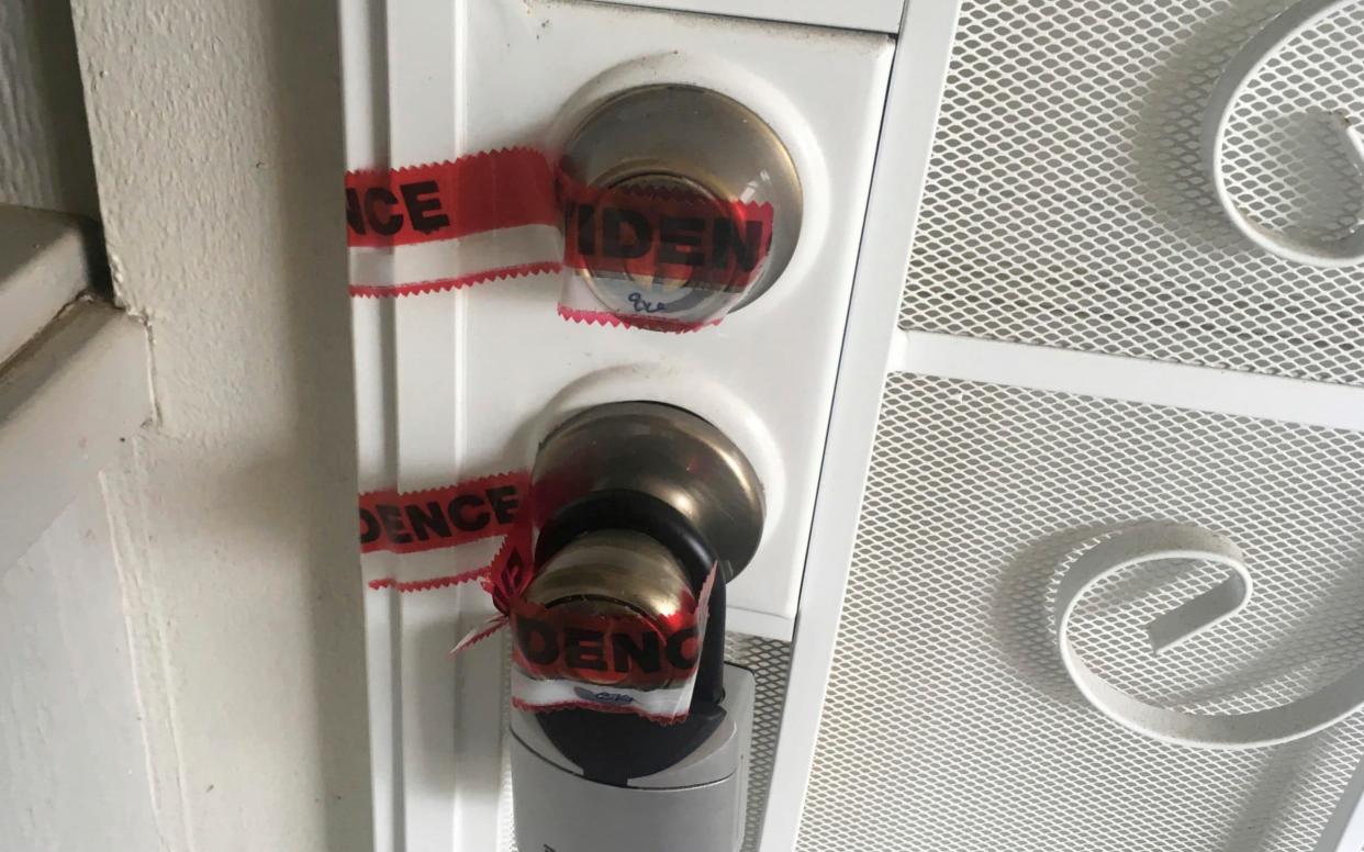 Red evidence tape covers part of the door leading to the condo where Ikaika Kang lives in Waipahu, Hawaii - AP