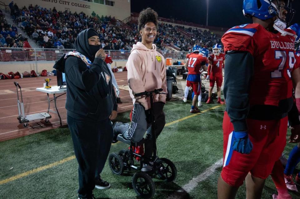 Injured Folsom player Rico Flores Jr. stands on the sidelines and watches the CIF Sac-Joaquin Division I championship playoff game Friday at Hughes Stadium at Sacramento City College.