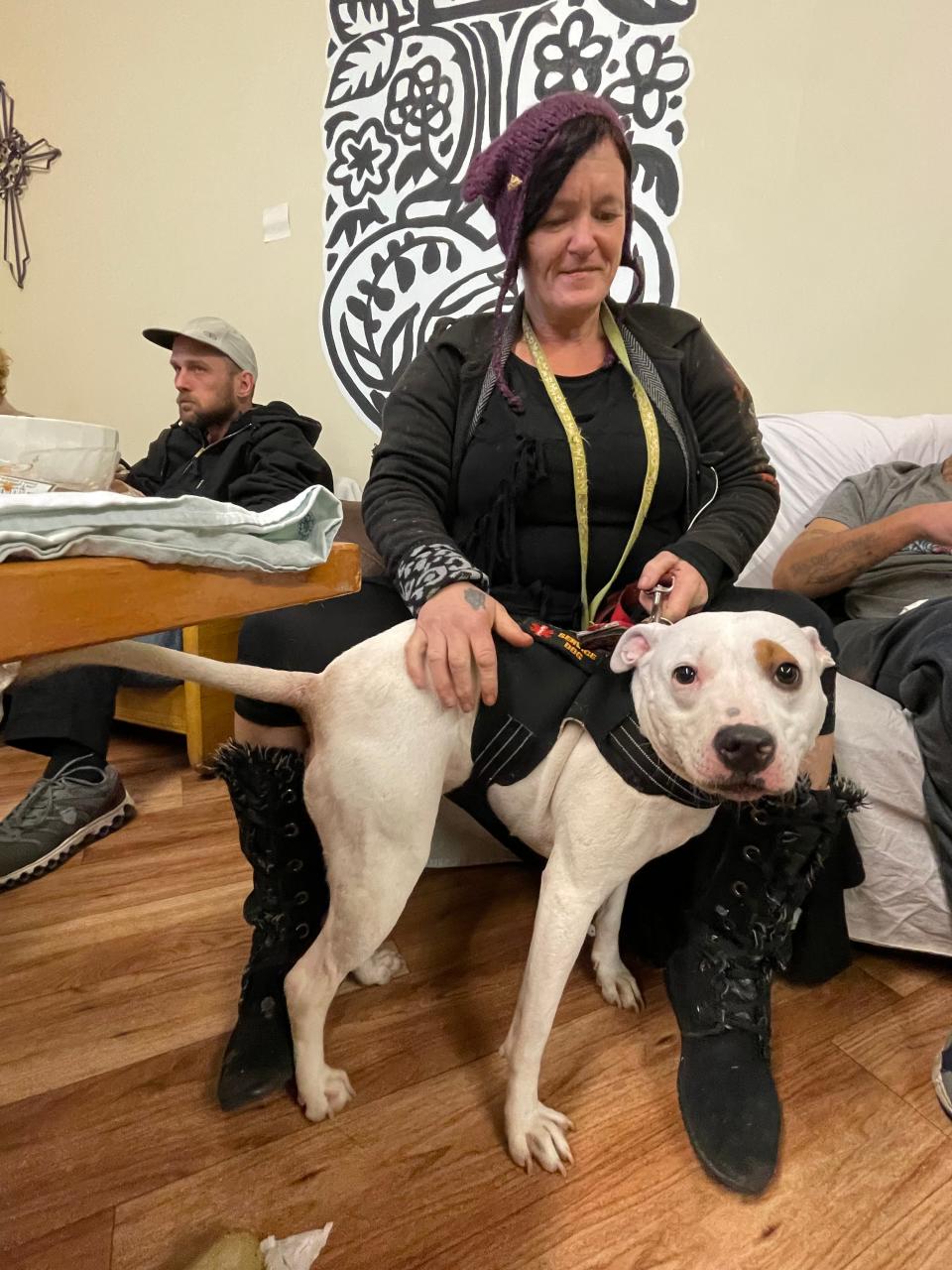 Julia Ippolito pets her psychiatric service dog, Cracker, during a weekly breakfast for homeless guests at Our Lady of the Road in South Bend.