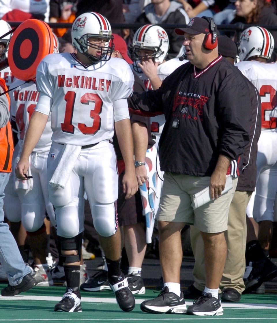 McKinley head coach Brian Cross speaks with quarterback Mike Shaffer during the first quarter of their game at Massillon in 2004.