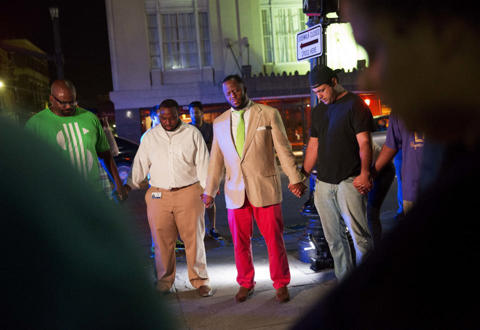 Worshippers gather to pray down the street from the Emanuel AME Church. (AP Photo/David Goldman)