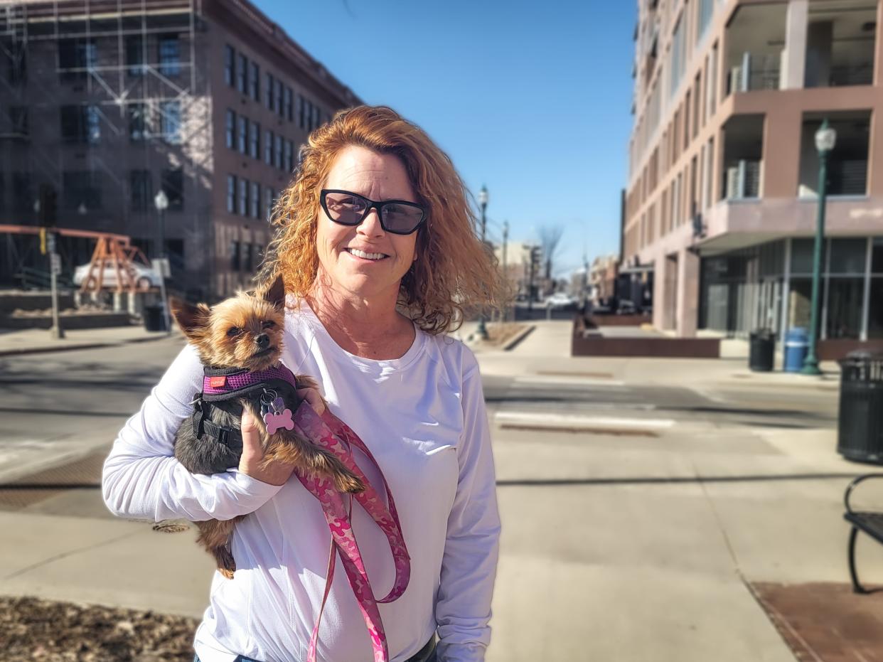 Michele Wellman and her dog, Kiki, pose for photo outside Washington Square Center on Wednesday, April 12, in downtown Sioux Falls.