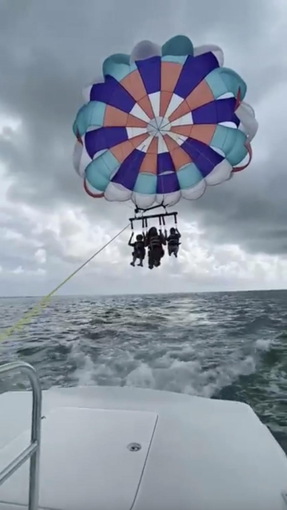 This screenshot made from a video released by the Alaparthi Family shows Supraja Alaparthi, 33, center, with her son and nephew as they parasail in the Florida Keys in June 2022. Alaparthi was killed after being dragged across the water while strapped into the parasail and slamming into a bridge. Attorneys representing the family have filed a wrongful death lawsuit against the captain, a crew member and a Florida resort company that owns the marina where the boat was based. (Alaparthi Family via AP)