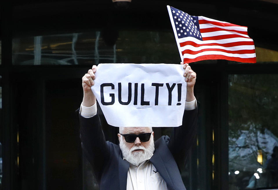 Protester Bill Christeson holds up a sign saying "guilty" as the first count of guilty comes in at he trial of former Donald Trump campaign chairman Paul Manafort, at federal court in Alexandria, Va., Tuesday, Aug. 21, 2018. (AP Photo/Jacquelyn Martin)