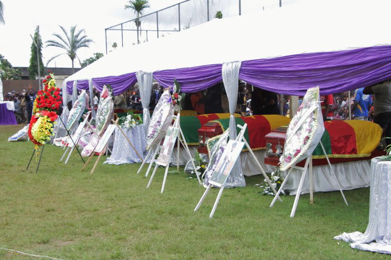 Flag-draped caskets of seven children who were killed by unidentified assailants in a classroom of a secondary school are pictured during their mass funeral in Kumba