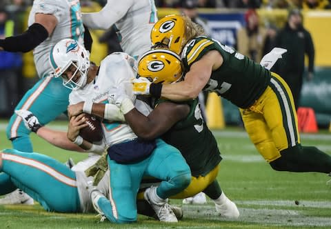 Miami Dolphins quarterback Brock Osweiler (8) is sacked by Green Bay Packers nose tackle Kenny Clark (97) and outside linebacker Clay Matthews (52) in the fourth quarter at Lambeau Field - Credit: Benny Sieu/USA Today