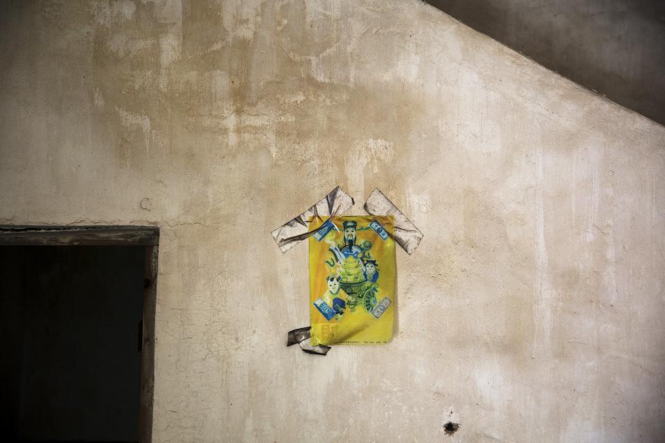 A picture of a Chinese God of Fortune is stuck to a wall in a house in the abandoned fishing village of Houtouwan on the island of Shengshan July 26, 2015. (REUTERS/Damir Sagolj)