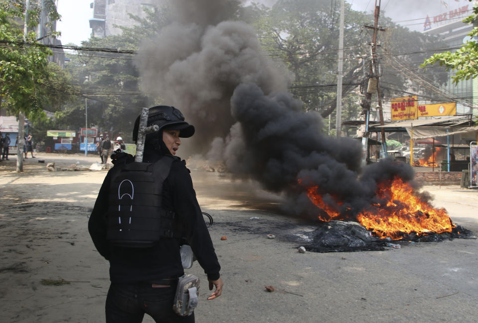 An anti-coup protester stands near a fire during a demonstration in Yangon, Myanmar, Saturday, March 27, 2021. As Myanmar’s military celebrated the annual Armed Forces Day holiday with a parade Saturday in the country’s capital, soldiers and police elsewhere reportedly killed dozens of people as they suppressed protests in the deadliest bloodletting since last month’s coup. (AP Photo)