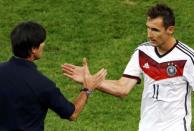 Germany's Miroslav Klose (R) shakes hands with coach Joachim Loew as he leaves the pitch during their 2014 World Cup final against Argentina at the Maracana stadium in Rio de Janeiro July 13, 2014. REUTERS/Leonhard Foeger