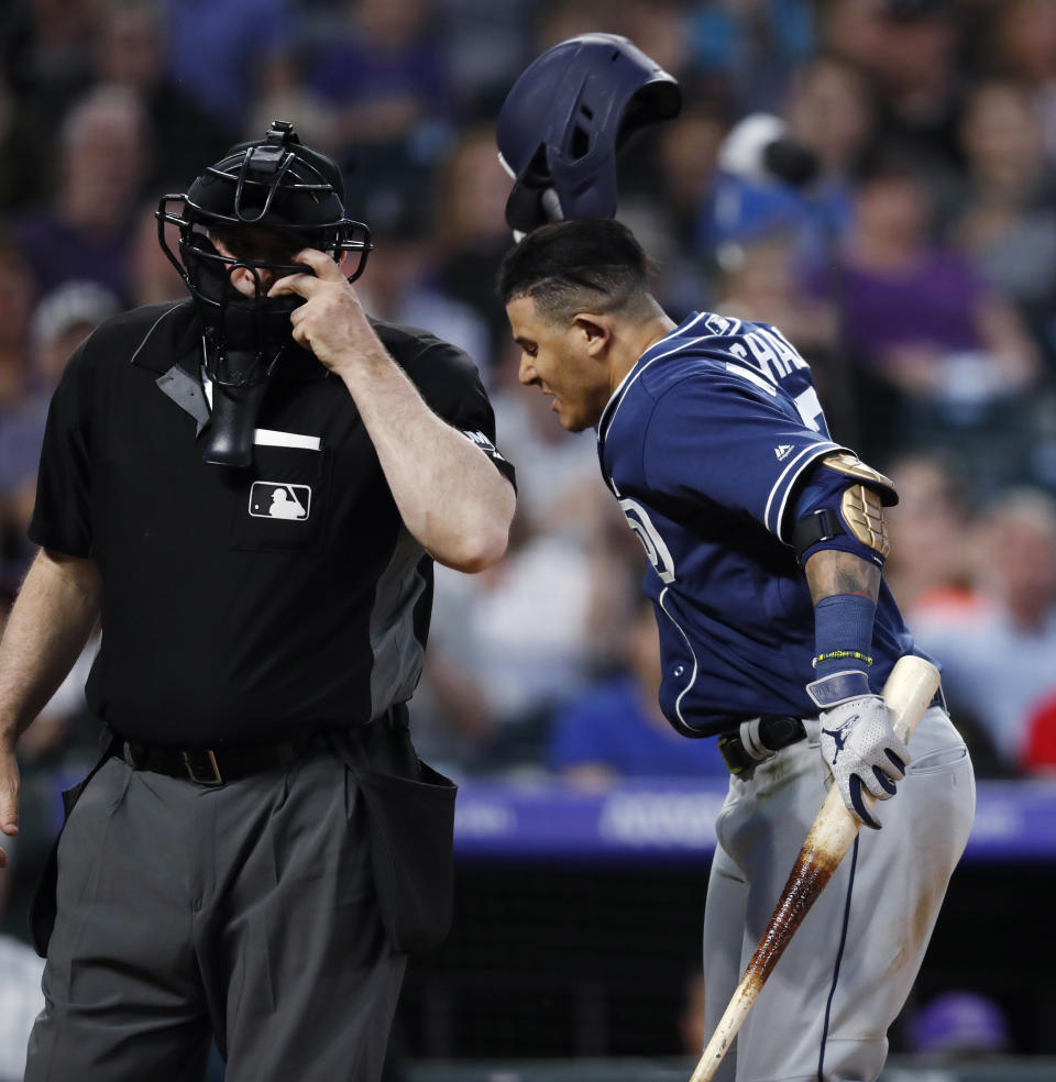 San Diego Padres' Manny Machado, right, throws down his helmet as he yells at home plate umpire Bill Welke, who had called Machado out on strikes during the fifth inning of the team's baseball game against the Colorado Rockies on Saturday, June 15, 2019, in Denver. (AP Photo/David Zalubowski)