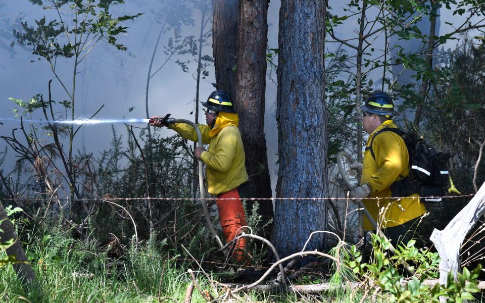 Emergency responders battle against the wildfires, which are being fanned by hurricane winds