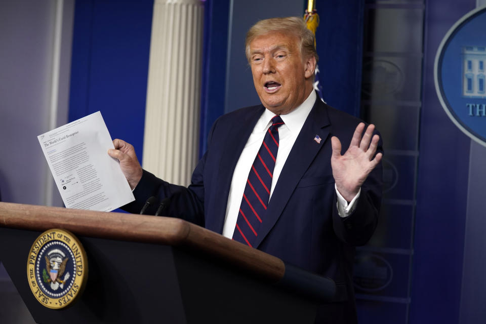 President Donald Trump holds an article as he speaks during a news conference at the White House, Thursday, July 30, 2020, in Washington. (AP Photo/Evan Vucci)