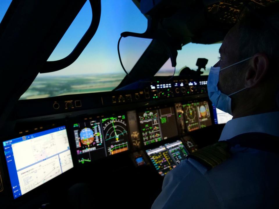 An Air France pilot wearing a protective mask trains in an Airbus A350 flight simulator at an Air France training centre near Charles de Gaulle airport as European safety rules require extra training for any pilot that has not carried out at least three take-offs and landings over the last three months, amid the coronavirus disease (COVID-19) outbreak near Paris, France, May 15, 2020. REUTERS/Noemie Olive