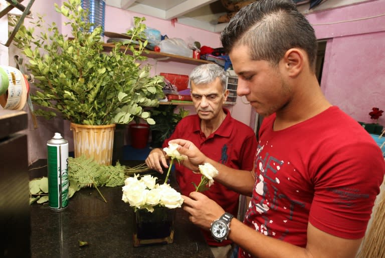 A picture taken on July 29, 2015 shows Ibarhim, an 18-year-old Syrian teenager, arranges flowers at a shop in Beirut