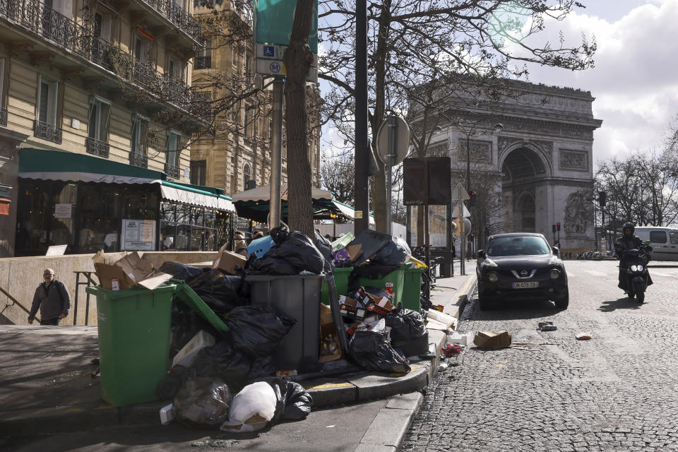 ARCHIVO - Basura sin recoger se ve apilada cerca del Arco de Triunfo de París, el 14 de marzo de 2023, durante una huelga prolongada de servicios de limpieza. (AP Foto/Thomas Padilla, Archivo)