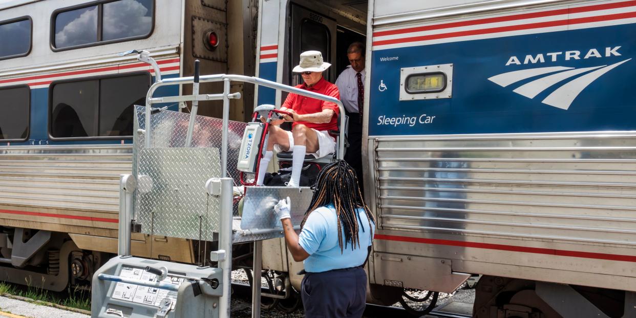 Florida, Orlando, Amtrak, passenger in wheelchair assisted boarding with crew.