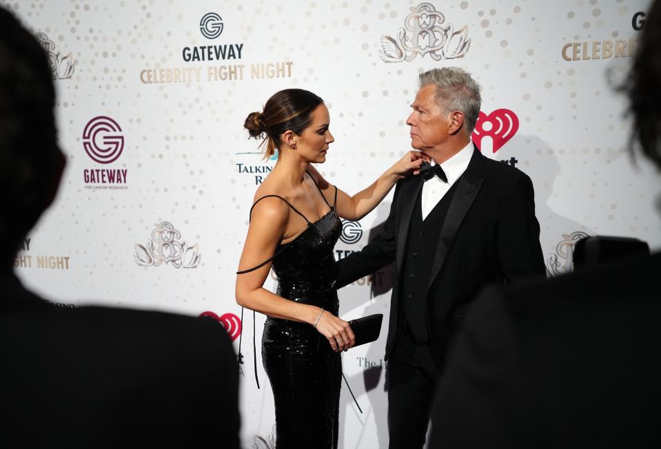 Katharine McPhee cleans up the tie of David Foster during the Red Carpet for Celebrity Fight Night at JW Marriott Phoenix Desert Ridge Resort & Spa on April 1, 2023.