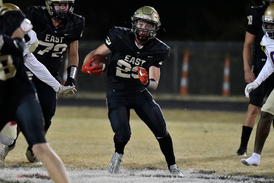 Bullitt East's Mason Gauthier (23) runs through an opening in the Male defensive line during action of their game, Friday, Oct. 21 2022 in Mt. Washington Ky.