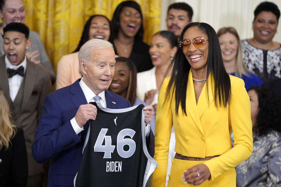 A'ja Wilson, of the WNBA's Las Vegas Aces, right, presents a jersey to President Joe Biden during an event to celebrate the 2023 WNBA championship team, in the East Room of the White House, Thursday, May 9, 2024, in Washington. (AP Photo/Evan Vucci)