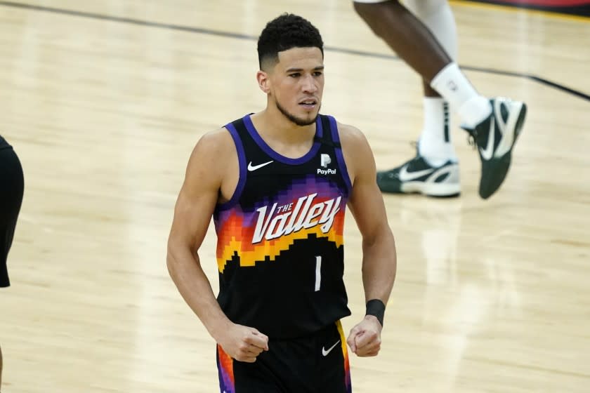 Phoenix Suns guard Devin Booker (1) pumps his fists after a basket against the Milwaukee Bucks during the second half of Game 1 of basketball's NBA Finals, Tuesday, July 6, 2021, in Phoenix. (AP Photo/Matt York)