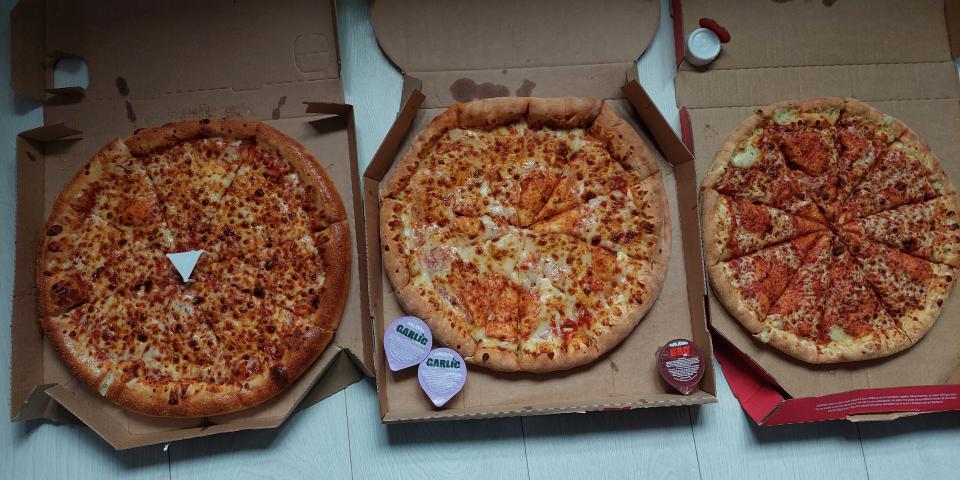 Pizza in boxes from Pizza Hut, Domino's, and Papa John's