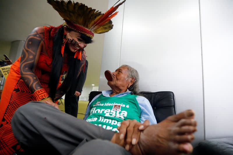 Brazil's indigenous chief Raoni Metuktire talks with an indigenous woman after a meeting with the parliamentary front in defense of the rights of indigenous people in Brasilia